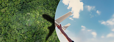 Zwei Bilder werden durch einen geschwungenen Bogen, dem CENA-Bogen, voneinander optisch getrennt. Auf dem linken Bild ist ein Wald abgebildet, auf dem ein Teil des Schattens eines Flugzeuges zu sehen ist. Auf dem rechten Bild hält eine Person einen Flugzeugmodell in den Himmel. Durch den Zusammenschluss beider Bilder ist ein vollständiges Flugzeug zu sehen.